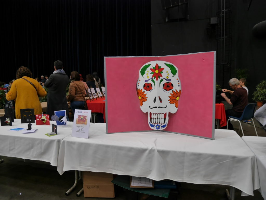 Grande carte pop-up en forme de tête de mort colorée, Fête du livre jeunesse de Firminy