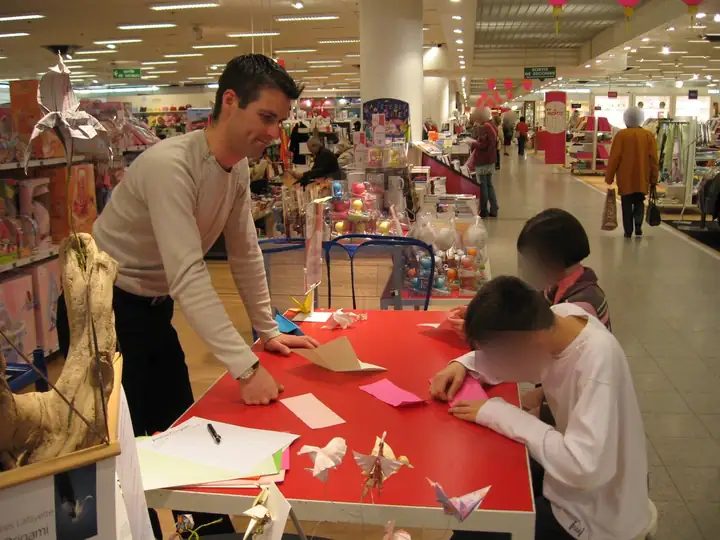 Atelier origami animé en grand magasin avec des enfants