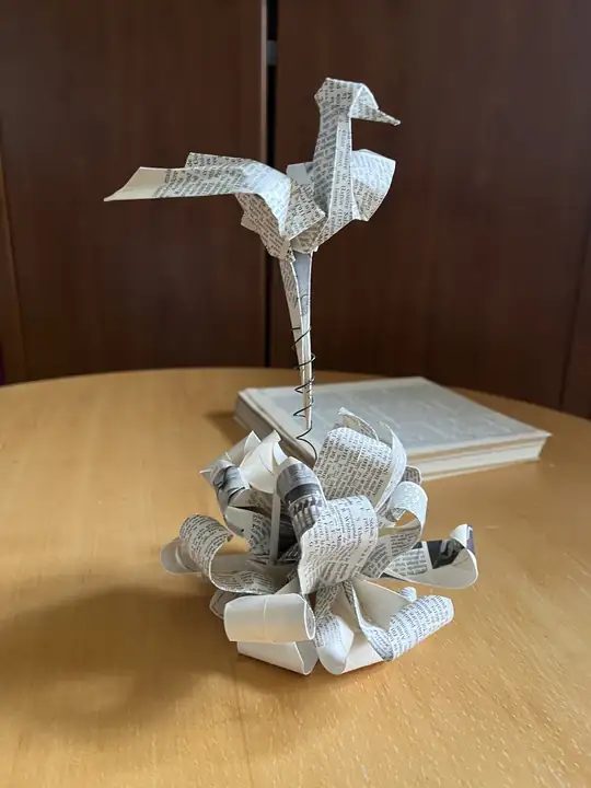 Grue en origami pliée dans des pages de livre